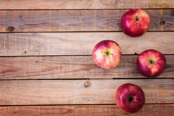 Fresh red apples on rustic wood table, shot from above, copyspace