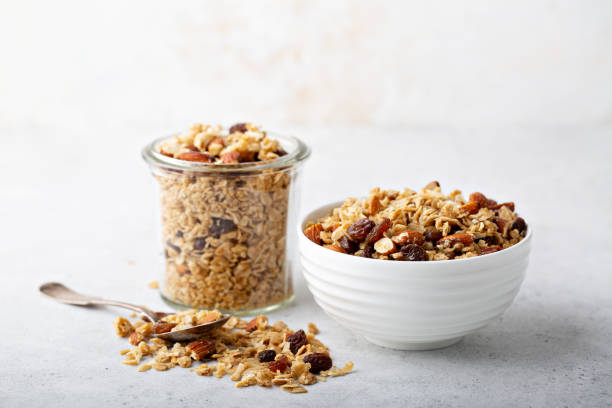 Homemade granola with coconut and almonds Homemade granola with coconut, raisins and almonds for breakfast in a jar and a bowl granola photos stock pictures, royalty-free photos & images