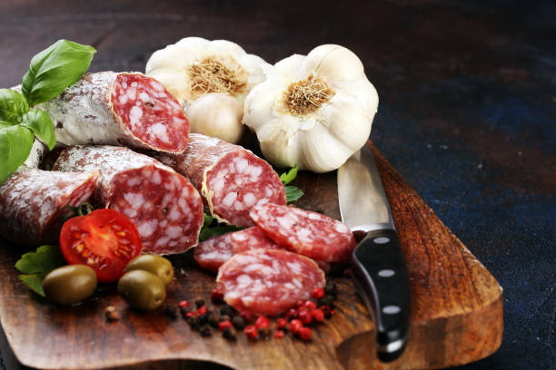 istock thinly sliced salami on a wooden texture on the background. 1194740237
