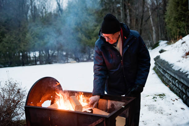 istock Senior man making a fire outdoors in winter 1194740250