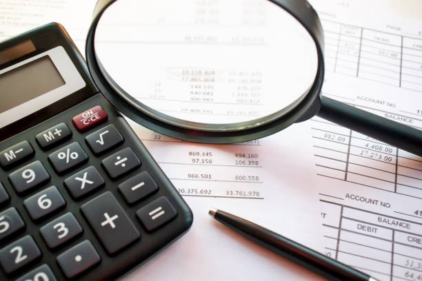 istock Magnifying glass with calculator on report.blue tone 1194740284