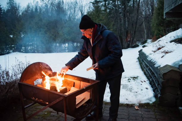 istock Senior man making a fire outdoors in winter 1194740287
