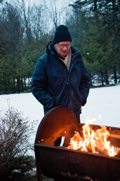 istock Senior man looking at a fire outdoors in winter 1194740330