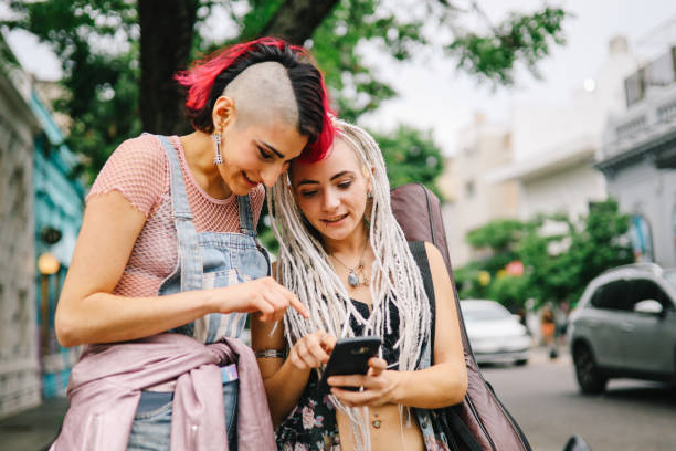 istock Two girls using smartphone in the street 1194741361