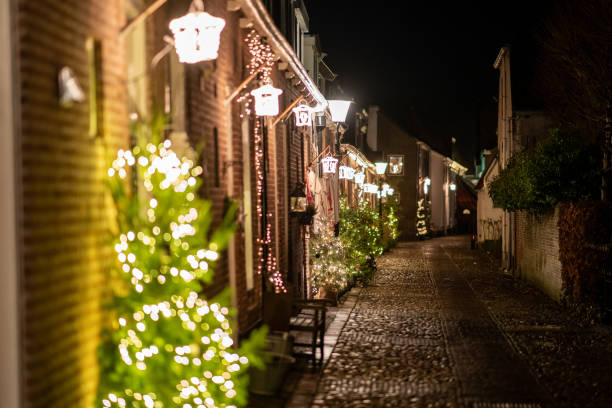 Rua estreita velha em uma cidade pequena com luzes de Natal atmosféricas - foto de acervo