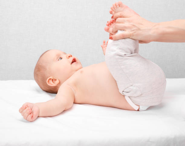 little baby receiving leg massage in pediatric clinic - reflexology massaging recovery sport imagens e fotografias de stock