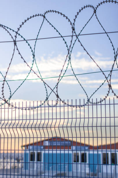 istock Barbed wire and fence against the sky 1194743504
