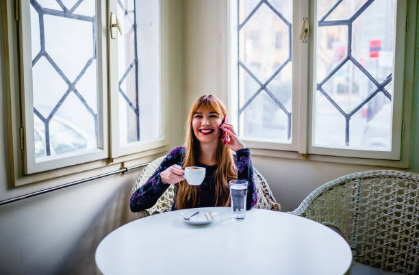 istock Woman drinking coffee and talking on the mobile phone 1194744706