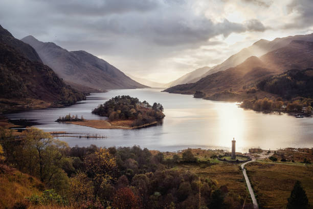 View with famous Scottish lake Loch Shiel with Glenfinnan monument on sunset Panoramic view with famous Scottish lake Loch Shiel with Glenfinnan monument and island on sunset, Scotland. scotland photos stock pictures, royalty-free photos & images