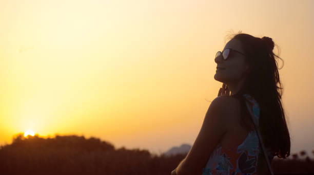 istock Young woman silhouette at sunset. 1194749096