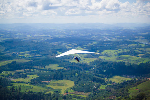 Hang glider in the blue sky. The sportsman flying on a hang glider Hang glider flying in the brazilian mountains. hang glider stock pictures, royalty-free photos & images