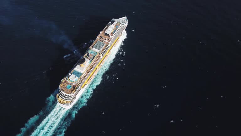 Aerial top view of stunning cruise ship at Black sea. Stock. Large cruise ship with people on the upper deck and a swimming pool with basketball field