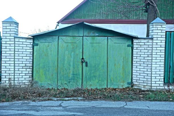 istock old iron green garage and gray brick fence 1194754628