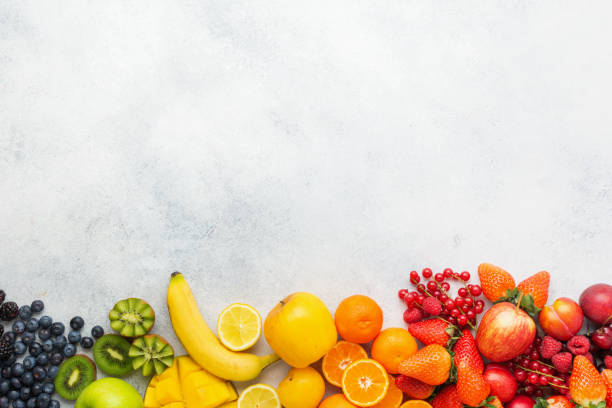 Rainbow fruits background Rainbow fruits berries background on white. Top view of strawberries blueberries cherries mango apple lemons oranges red currants plums blackberries, selective focus plum red white purple stock pictures, royalty-free photos & images