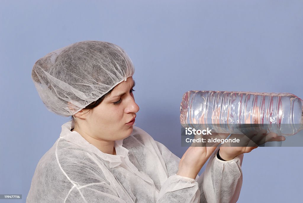 Hembra de fábrica trabajador inspeccionar una botella de agua - Foto de stock de Adulto libre de derechos