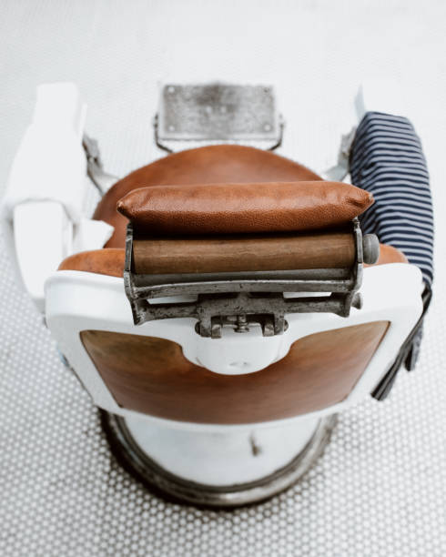 Old fashioned, retro style leather and metal barber chair with cape.