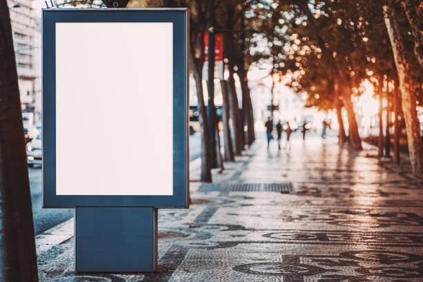 istock Outdoor mockup of a blank information poster on patterned paving-stone; an empty vertical street banner template in an alley; billboard placeholder mock-up on a city boulevard in an alleyway outdoors 1194776921