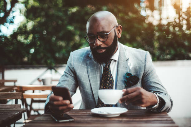 istock Elegant black guy phoning in a cafe 1194777542