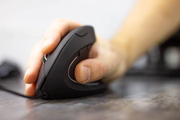 man’s hand uses a vertical ergonomic computer mouse-joystick. stock photo