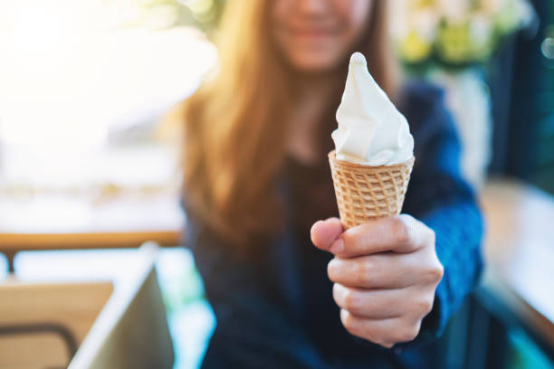 uma mulher que prende e que mostra o cone macio do waffle do gelado do saque - soft serve ice cream - fotografias e filmes do acervo