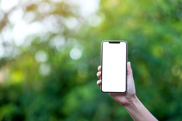 istock a hand holding black mobile phone with blank desktop screen with green nature background 1194779153
