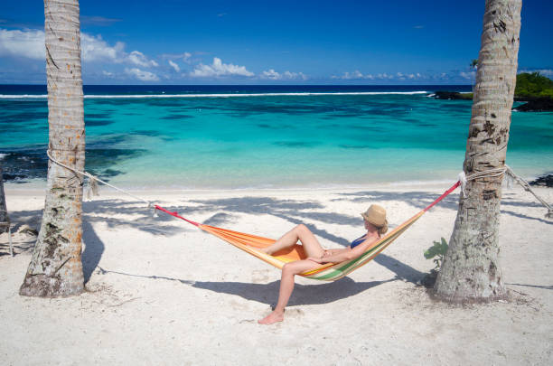 istock Woman relaxing in hammock on a beach 1194781767