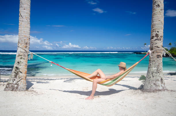 istock Woman relaxing in hammock on a beach 1194781771