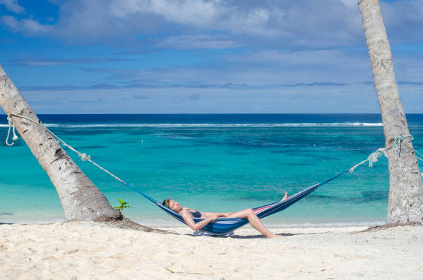 istock Woman relaxing in hammock on a beach 1194781783