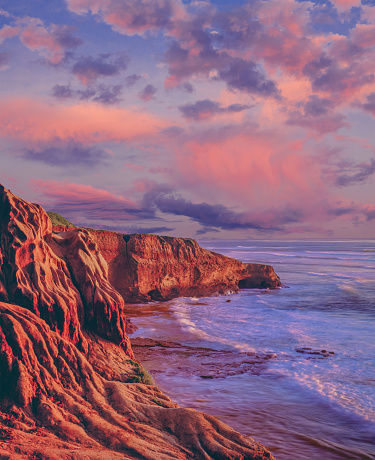 Eroded cliffs with majestic clearing storm clouds along the shoreline of San Diego. CA