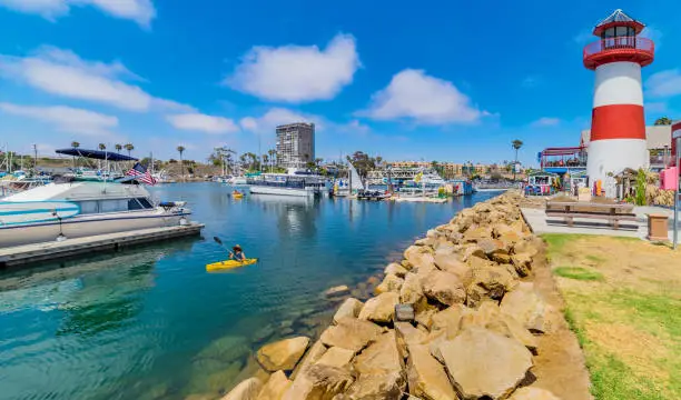A lone kayaker in the calm harbor waters of the tourist village of Oceanside, CA. North of San Diego