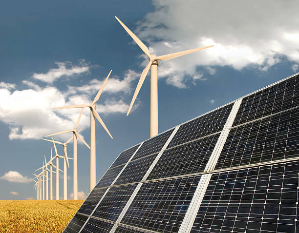 Solar panels and wind energy plants on a field stock photo