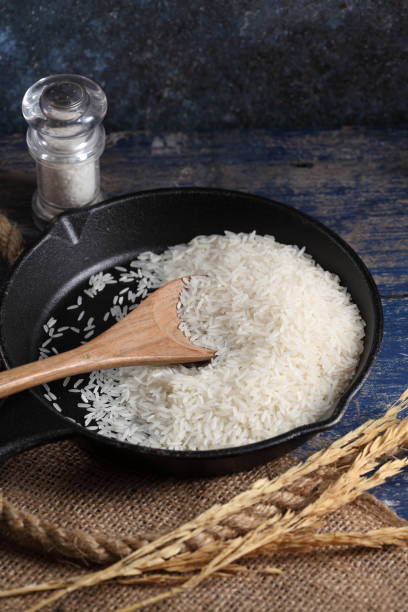 istock Close up white rice in measuring cup on table, Thai Jasmine rice in rustic kitchen background 1194784632