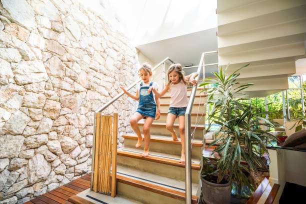 dos niñas corriendo por las escaleras - running down fotografías e imágenes de stock