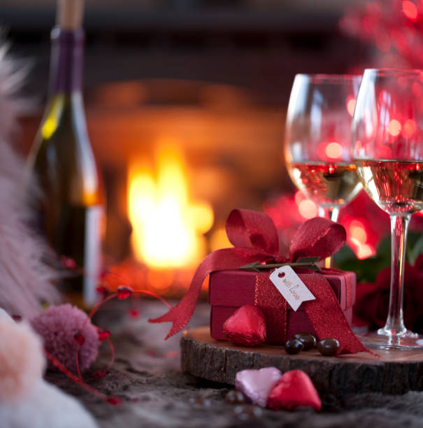 istock Valentine's Day White Wine and a Gift in Front of Fireplace with Chocolates 1194796949