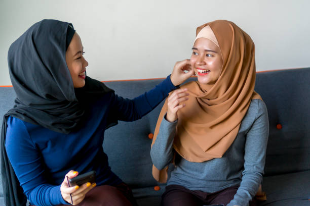 istock Two Malay friends wearing hijab at the sofa 1194801298