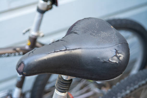 Old weathered tearing black bicycle seat