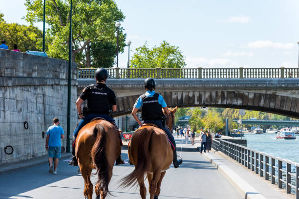 Two mounted police officers on horses are patrolling through the walkway of the seine river in downtown of Paris, France. stock photo