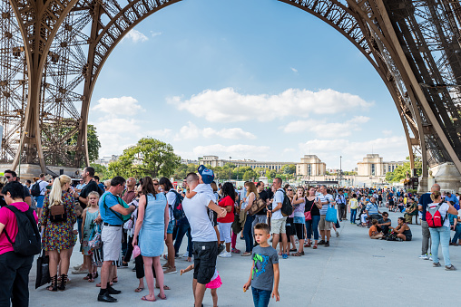 A lot of tourists at the ground floor of Eiffel Tower , a wrought-iron lattice tower on the Champ de Mars in Paris, France, named after the engineer Gustave Eiffel, constructed from 1887 to 1889.