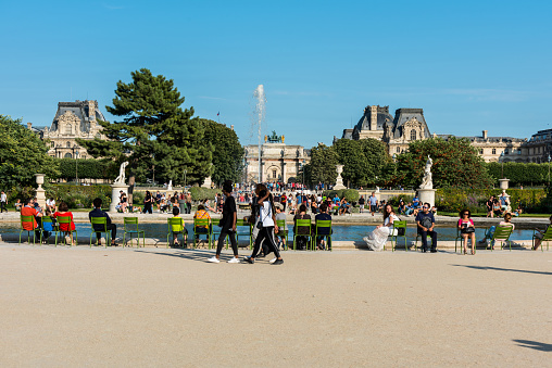 Tourists at the fountain in The Jardin Des Tuileries Paris,  a public garden located between the Louvre and the Place de la Concorde