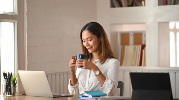 istock Coffee break, young creative woman holding coffee cup and smiling. 1194812847