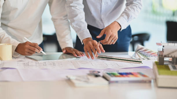 istock Architecture brainstorming with tablet and blueprints. 1194812861