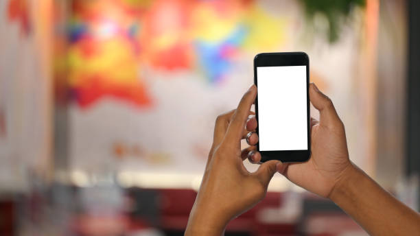 istock Man's hands holding smartphone with empty screen and bokeh on festival blurred background. 1194813804