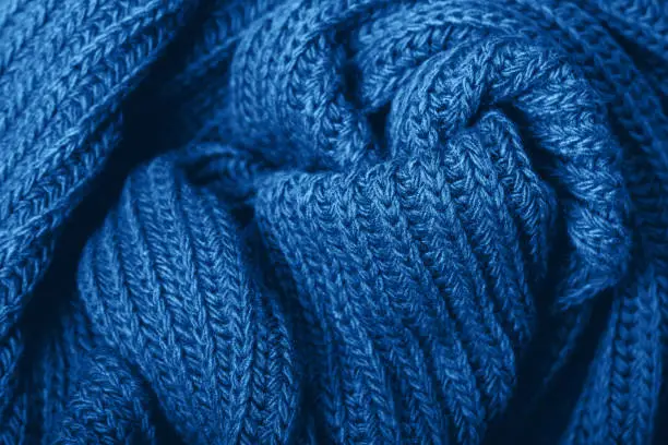 Knitted scarf texture. Classic blue color. The concept of cozy, comfort, warm, softness or winter
