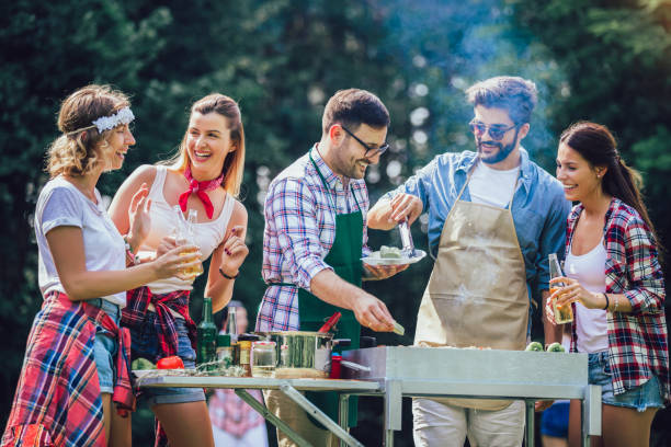istock Young friends having fun grilling meat enjoying barbecue party. 1194815049