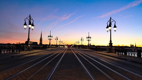 Selective focus of Tramway rails tracks in sunset light at Pont de pierre crossing Garonne river, Bordeaux,France