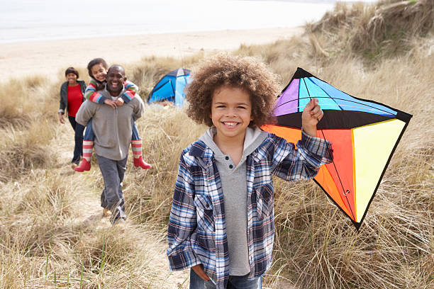 Family having fun with kite in the sand dunes stock photo