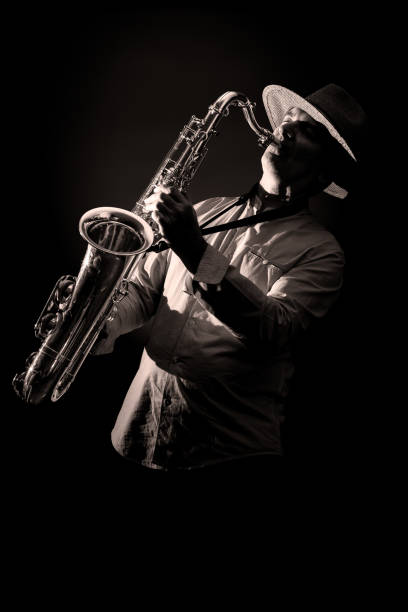 istock Saxophone Player in Concert - black and white isolated on black background 1194819552