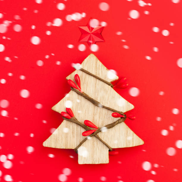 istock Christmas tree with snow on red background 1194820275