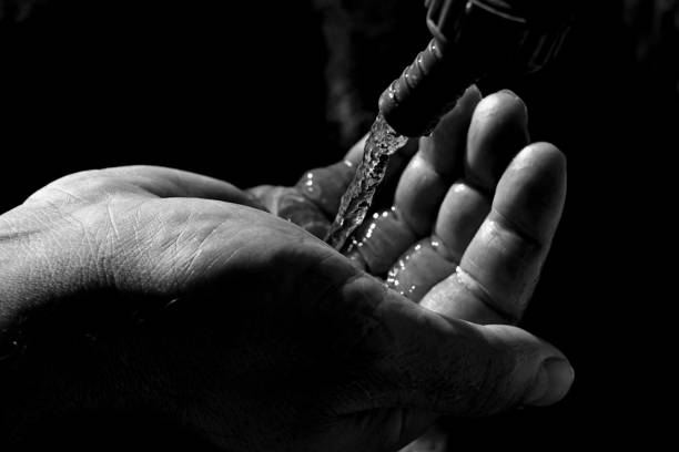 istock Closeup of man hand catching water/ Hands catching clean falling water 1194822741