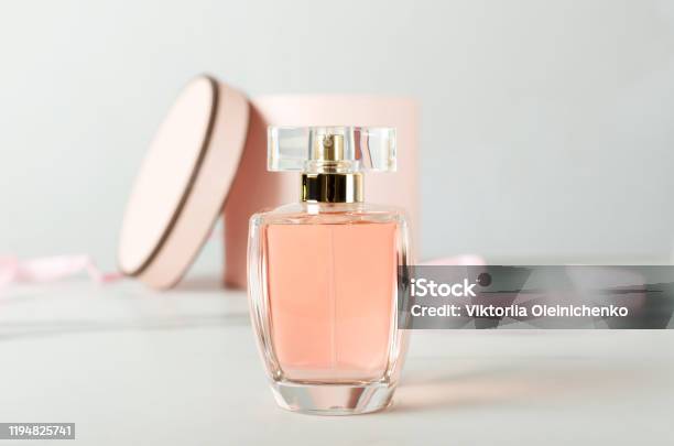 Close Up Of Glass Bottle Of Perfume And Opened Gift Box As A Background On The White Surface Stock Photo - Download Image Now